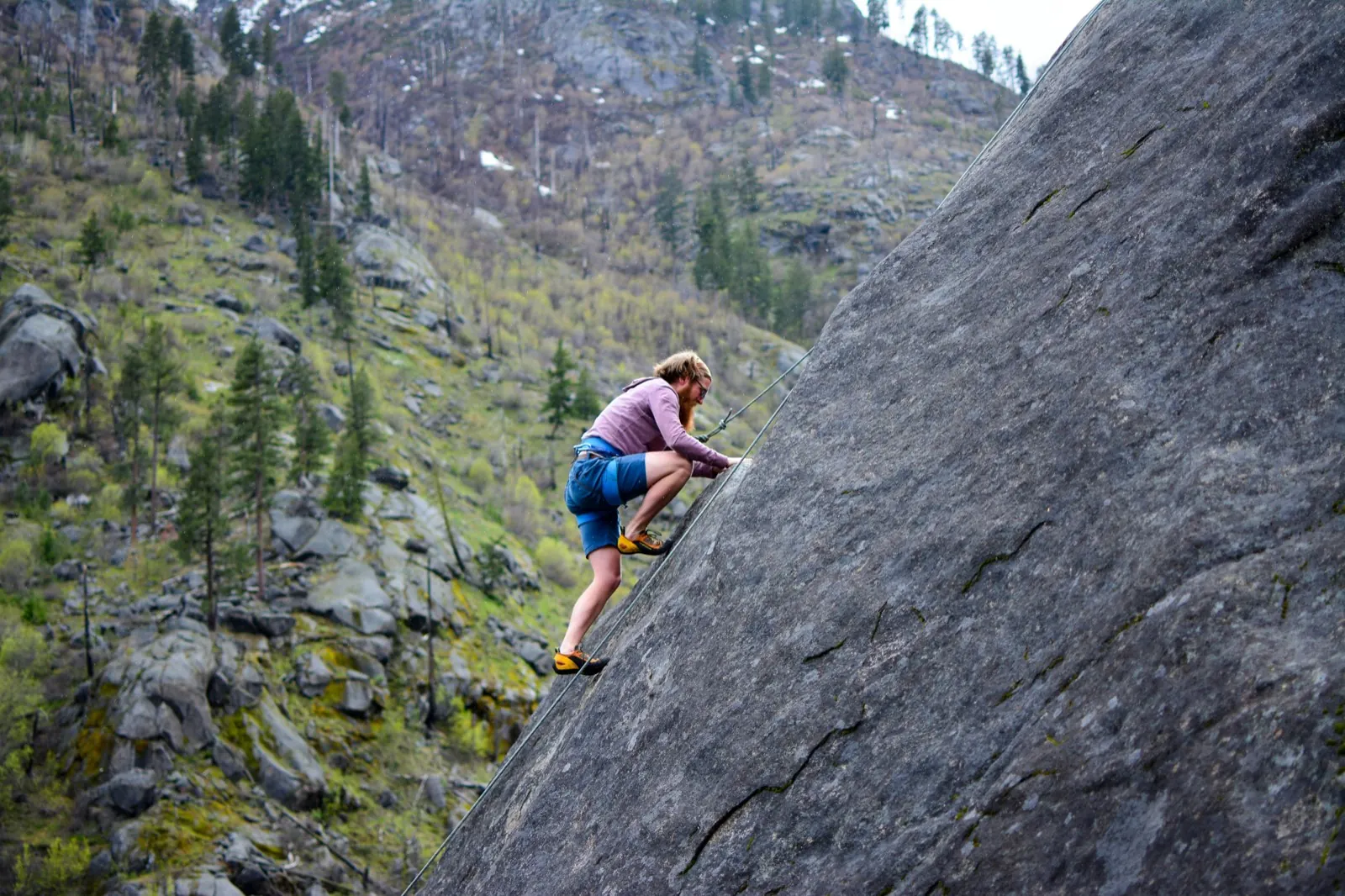 A climber ascending a granite slab