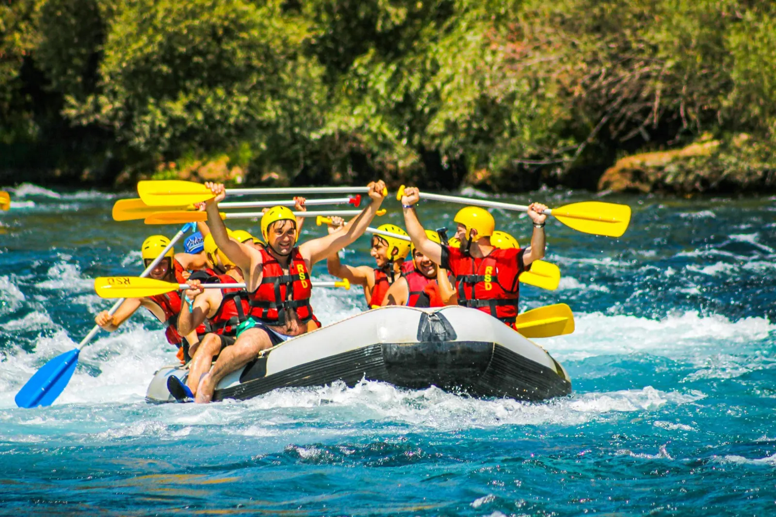 A team white water rafting through rapids